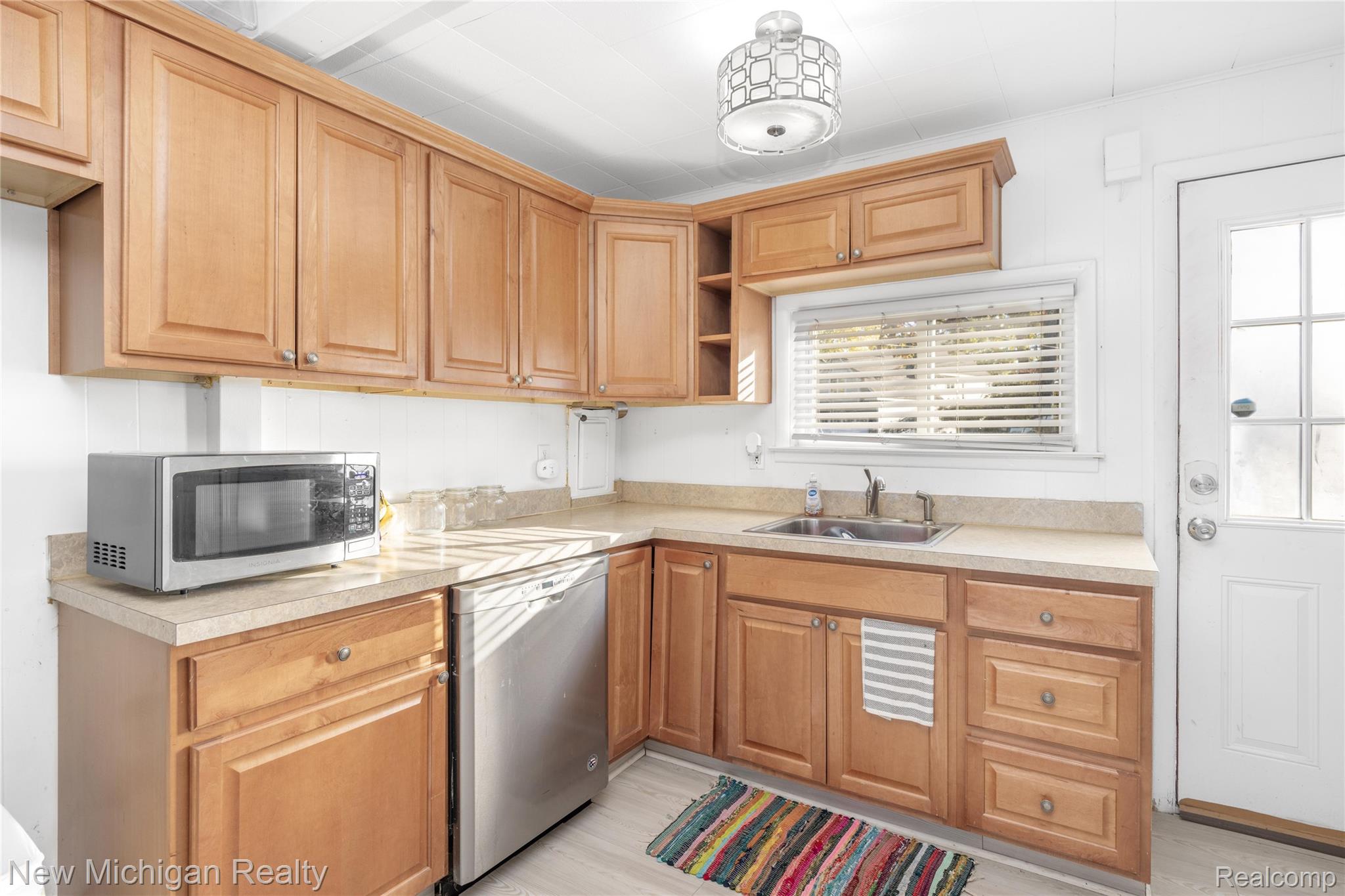 8665 Cooley Lake Road Commerce Township, MI 48382 - Photo 23 of 52 Kitchen with open shelves, stainless steel appliances, light countertops, and light wood-style floors