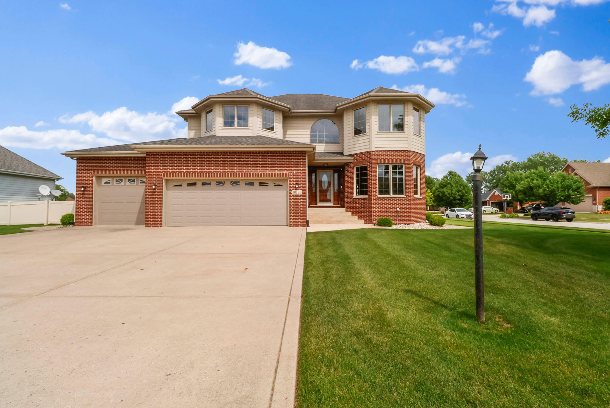 a view of a big house with a big yard and large trees
