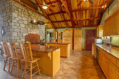 a living room with furniture a flat screen tv and floor to ceiling window