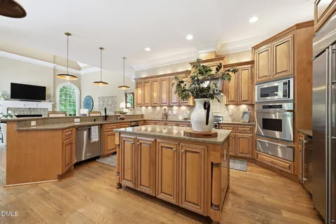 a dining room with furniture a chandelier and wooden floor