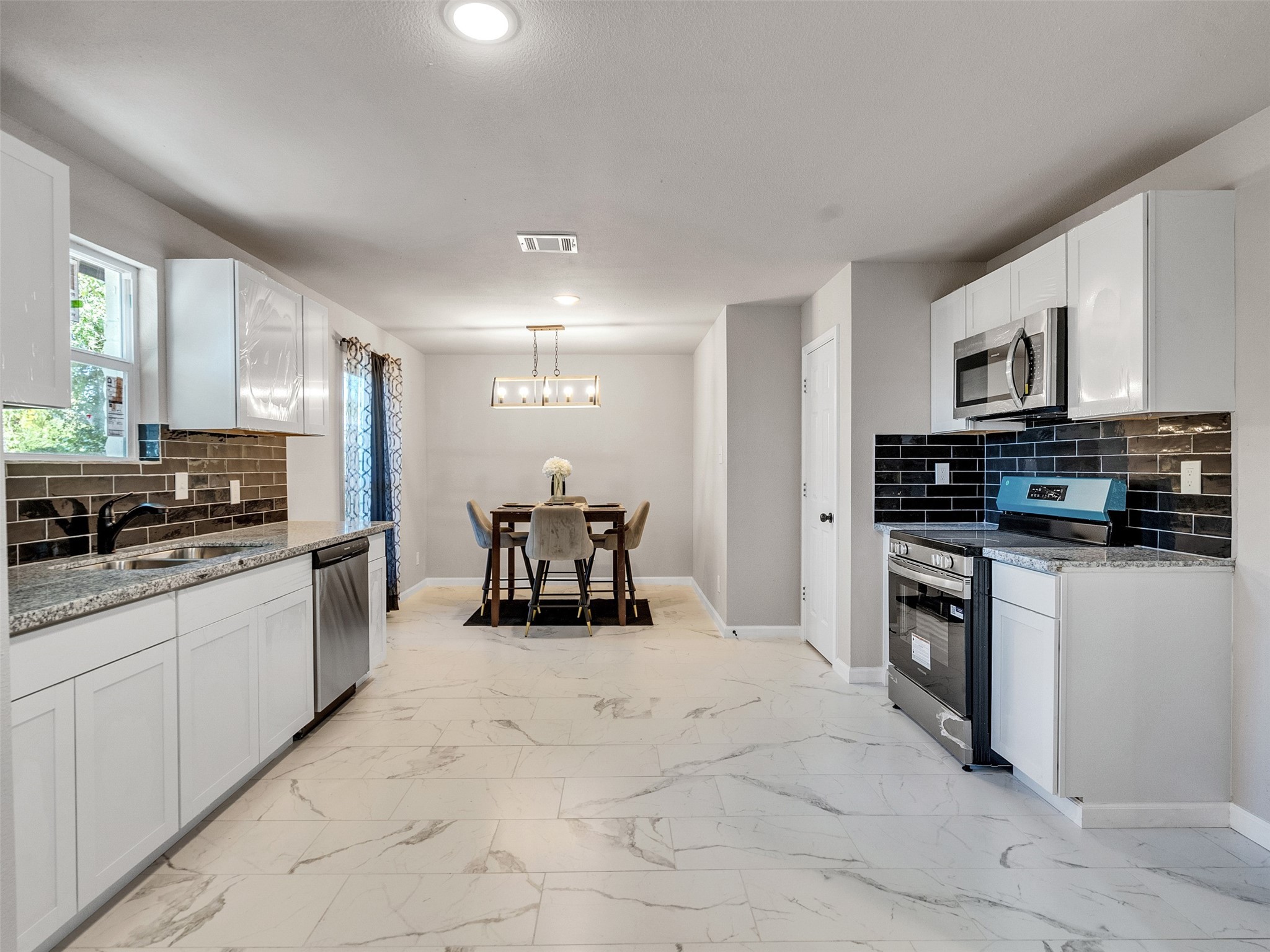 15123 Kaler Road Houston, TX 77060 - Photo 7 of 19 a large white kitchen with stainless steel appliances granite countertop a stove and a sink