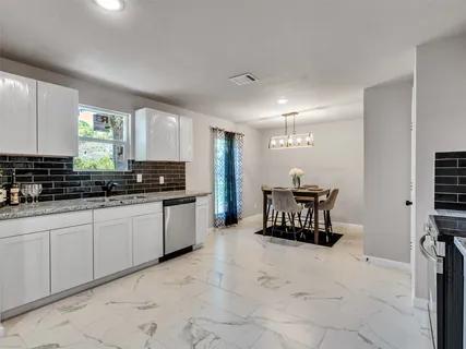 a large white kitchen with a large window