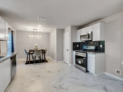 a kitchen with stainless steel appliances a stove a sink a microwave and a refrigerator