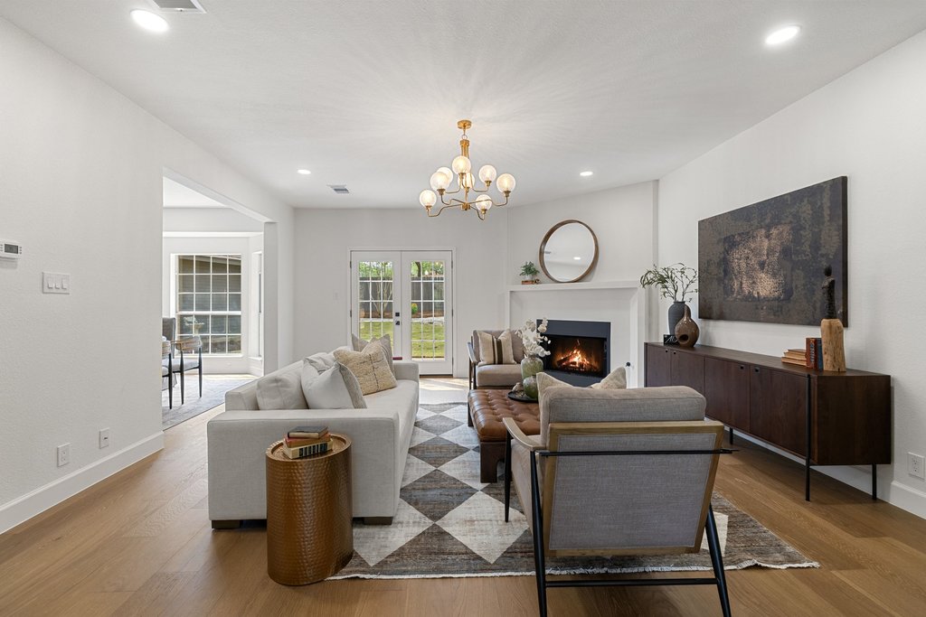 7516 Orrick Drive Austin, TX 78749 - Photo 11 of 40 a living room with furniture a fireplace and a chandelier