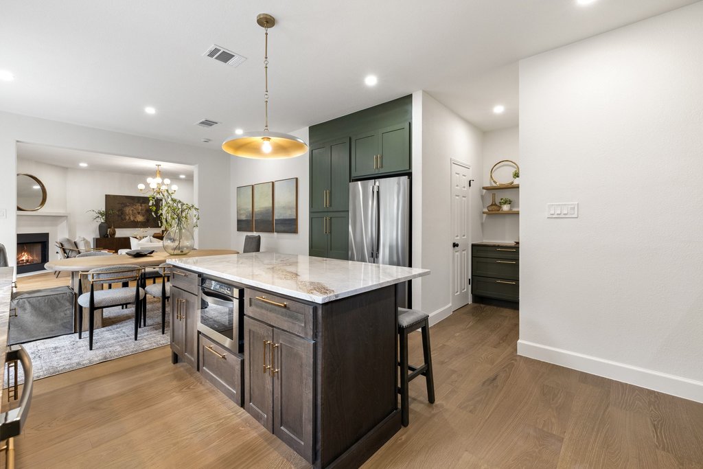 7516 Orrick Drive Austin, TX 78749 - Photo 17 of 40 a kitchen with kitchen island a wooden floor and white cabinets