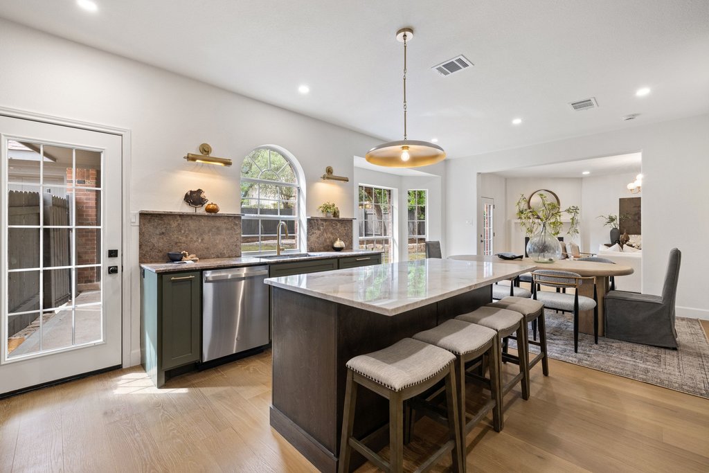 7516 Orrick Drive Austin, TX 78749 - Photo 19 of 40 a kitchen with stainless steel appliances granite countertop a stove a sink a dining table and chairs with wooden floor