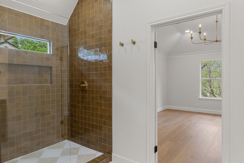 7516 Orrick Drive Austin, TX 78749 - Photo 29 of 40 a bathroom with a glass shower door and a window