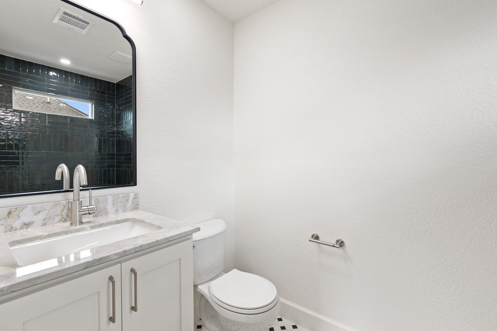 7516 Orrick Drive Austin, TX 78749 - Photo 36 of 40 a bathroom with a granite countertop sink a toilet and a mirror