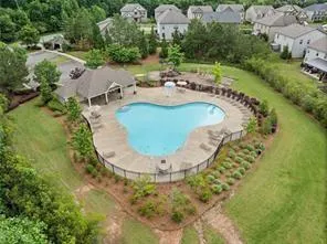 an aerial view of a house with a yard and greenery