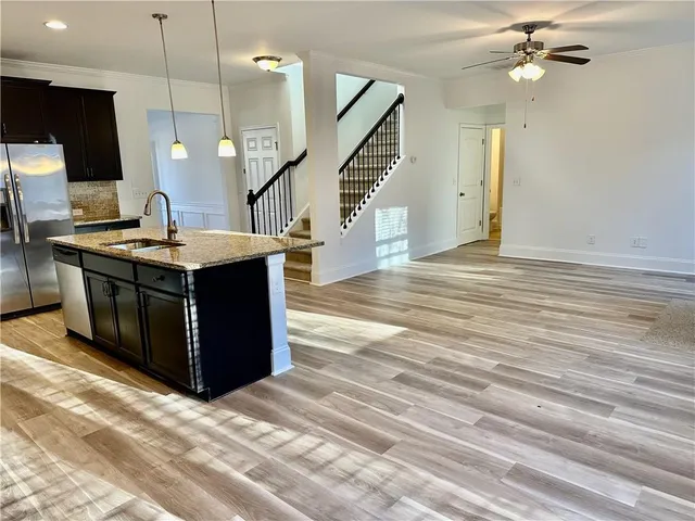 a view of kitchen with kitchen island granite countertop stainless steel appliances and a counter top space