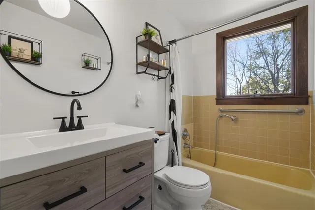 a bathroom with a sink a mirror a toilet and a shower