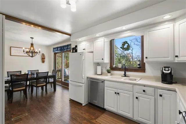 a kitchen with white cabinets and wooden floor