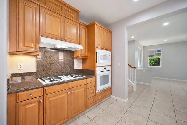 a kitchen with stainless steel appliances granite countertop a refrigerator and a sink