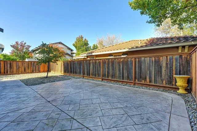 a patio with table and chairs and potted plants