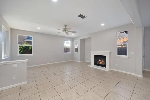 a view of an empty room with a window and fireplace