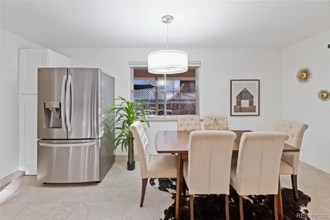 a dining room with furniture and a refrigerator