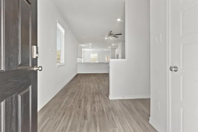 a view of a hallway with wooden floor and staircase