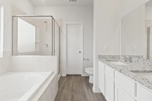 a bathroom with a granite countertop sink a toilet and bathtub