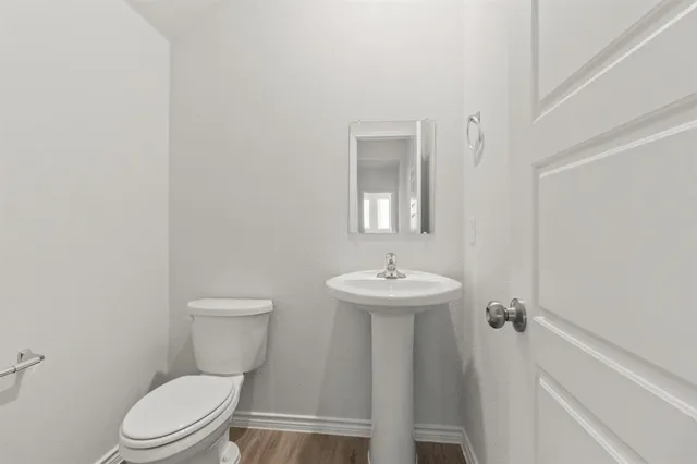 a bathroom with a toilet a sink and mirror