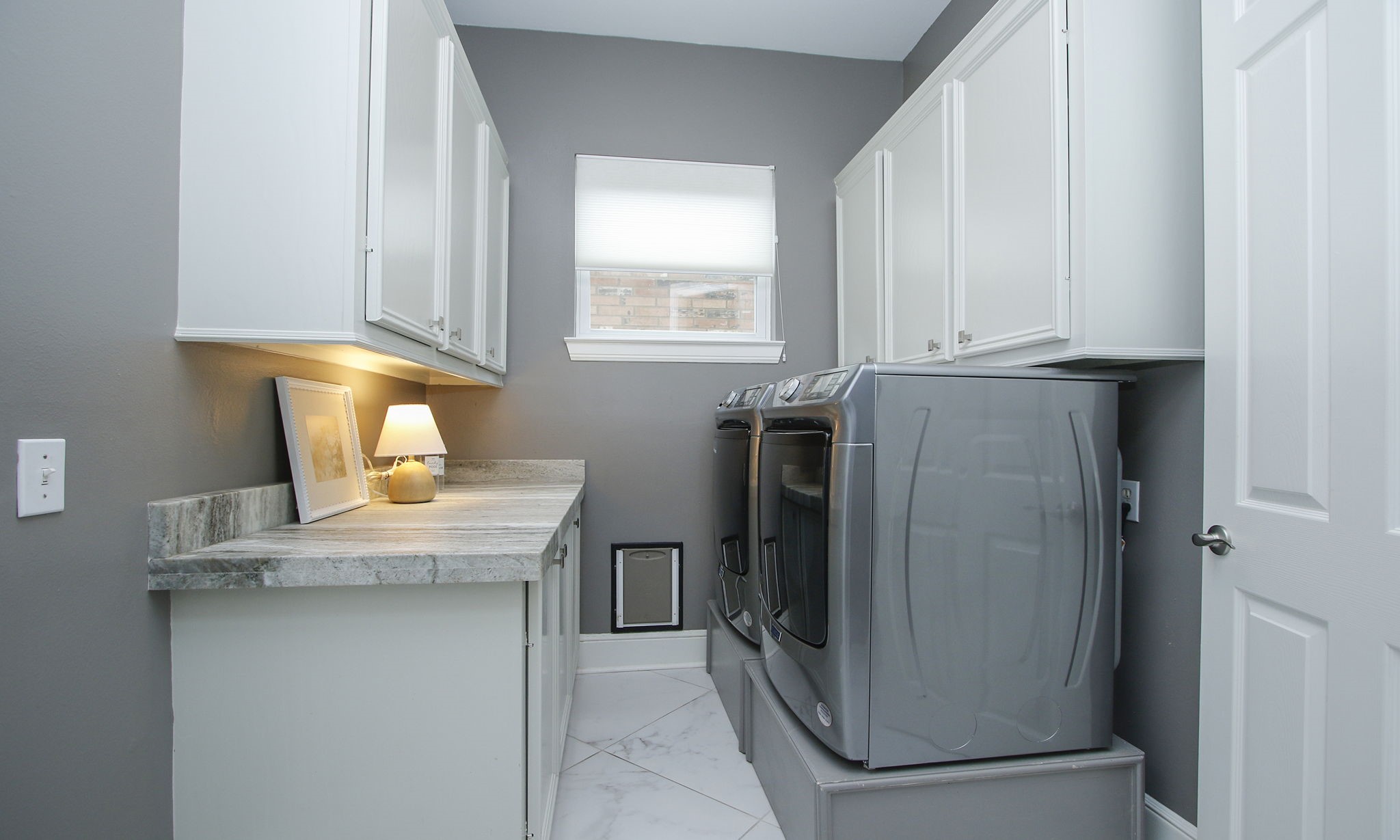 16610 Manningtree Lane Spring, TX 77379 - Photo 29 of 50 The laundry room was also remodeled with granite counters and plenty of storage cabinets. The floors are 24" x 24" marble look porcelain tile.