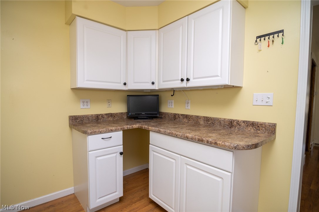 53341 Key Bellaire Road Bellaire, OH 43906 - Photo 32 of 48 Kitchen featuring white cabinetry, dark countertops, light wood-type flooring, and built in desk