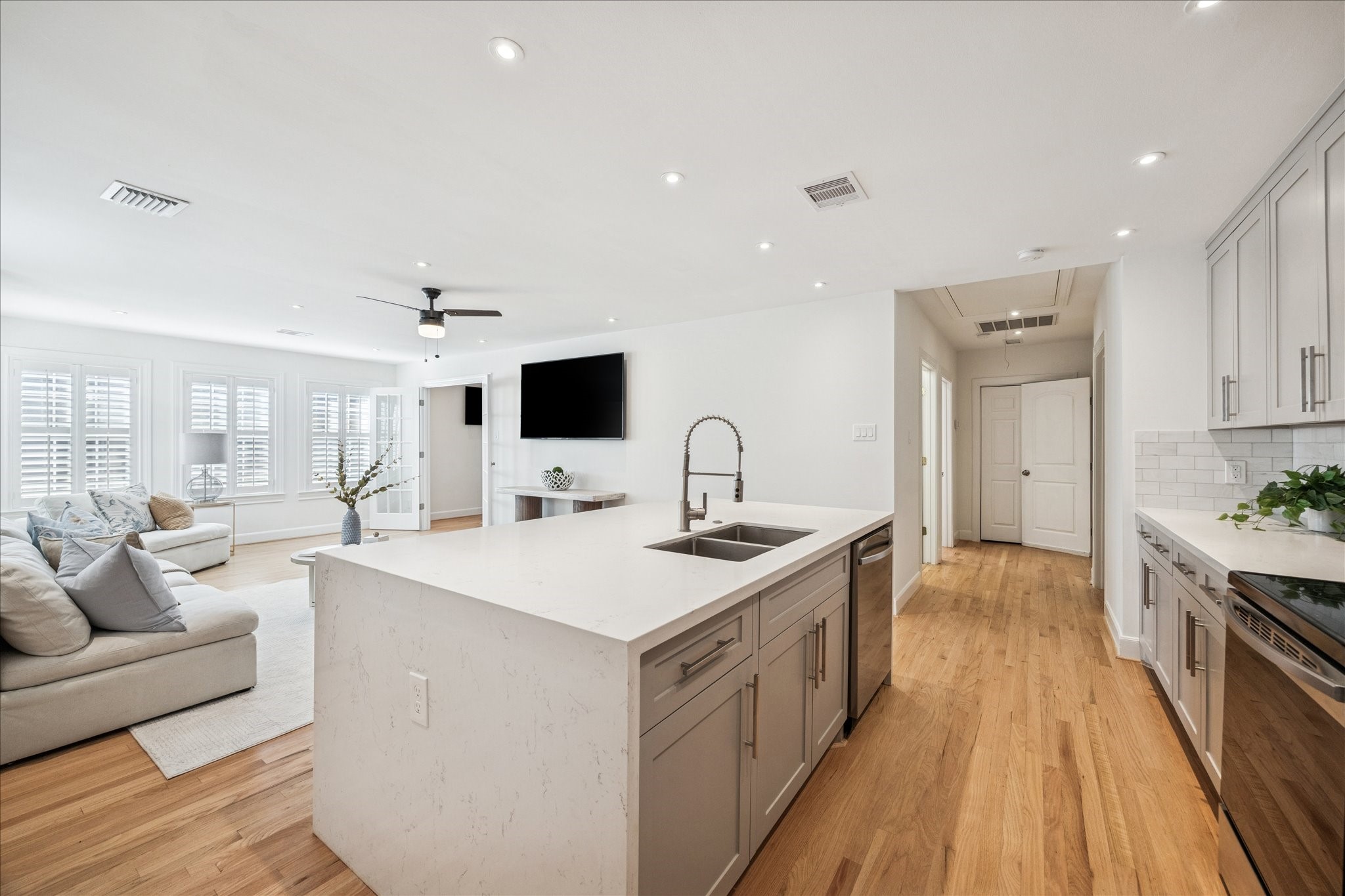 2409 Dryden Road Houston, TX 77030 - Photo 21 of 32 The view from the kitchen overlooks the living room and entry hall, reinforcing the open, connected layout of the apartment. Convenient access to the private laundry area is located just off the entry, adding everyday functionality.