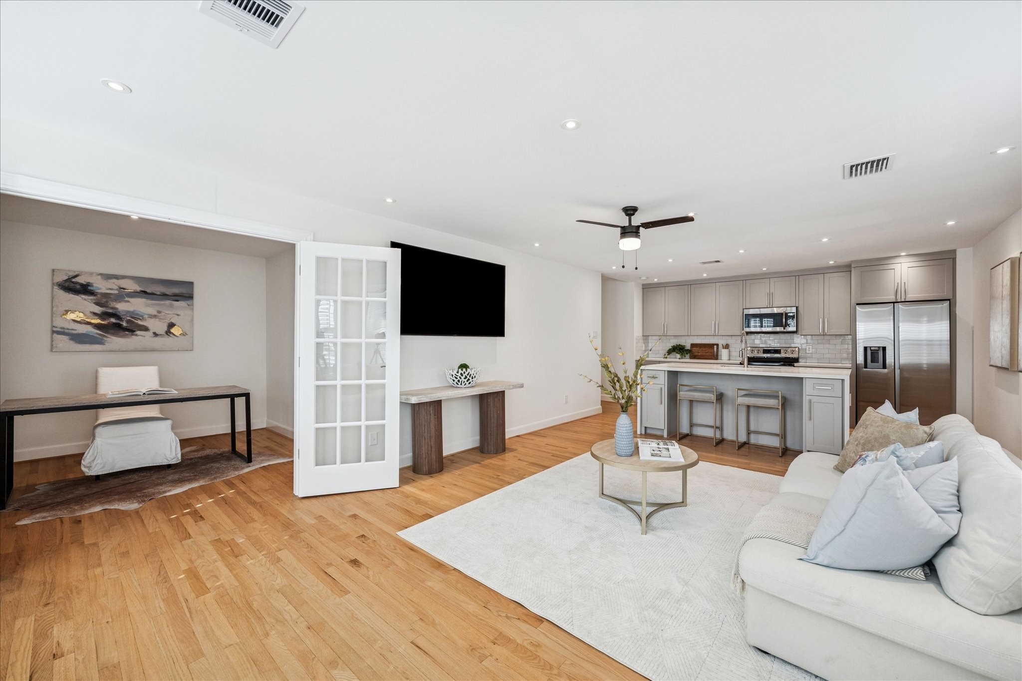 2409 Dryden Road Houston, TX 77030 - Photo 25 of 32 An overall view showcases the open connection between the study/media room, living area, and kitchen, highlighting the thoughtful layout and sense of flow. The arrangement allows each space to feel distinct while remaining comfortably connected.