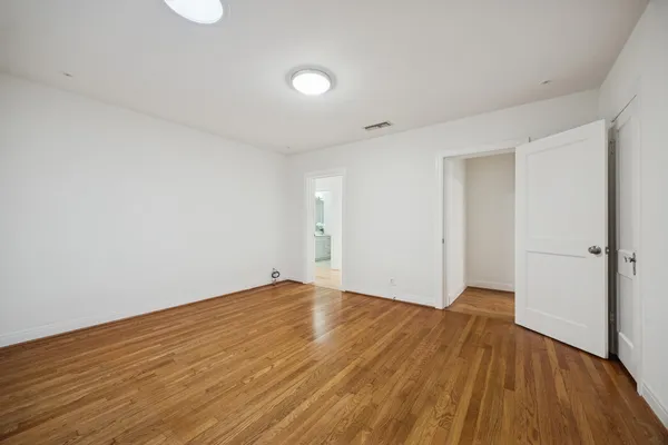 a view of an empty room with wooden floor