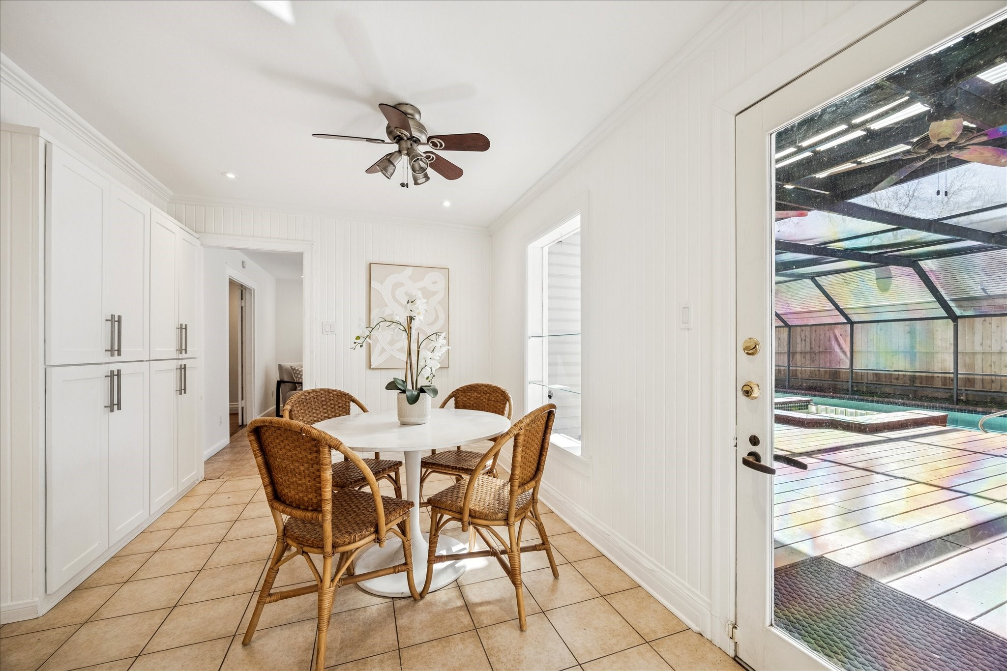 2409 Dryden Road Houston, TX 77030 - Photo 8 of 32 The breakfast room overlooks a Florida-style pool, creating a bright and inviting backdrop for everyday meals. A wall of built-in cabinets provides generous storage while adding architectural interest and functionality to the space.
