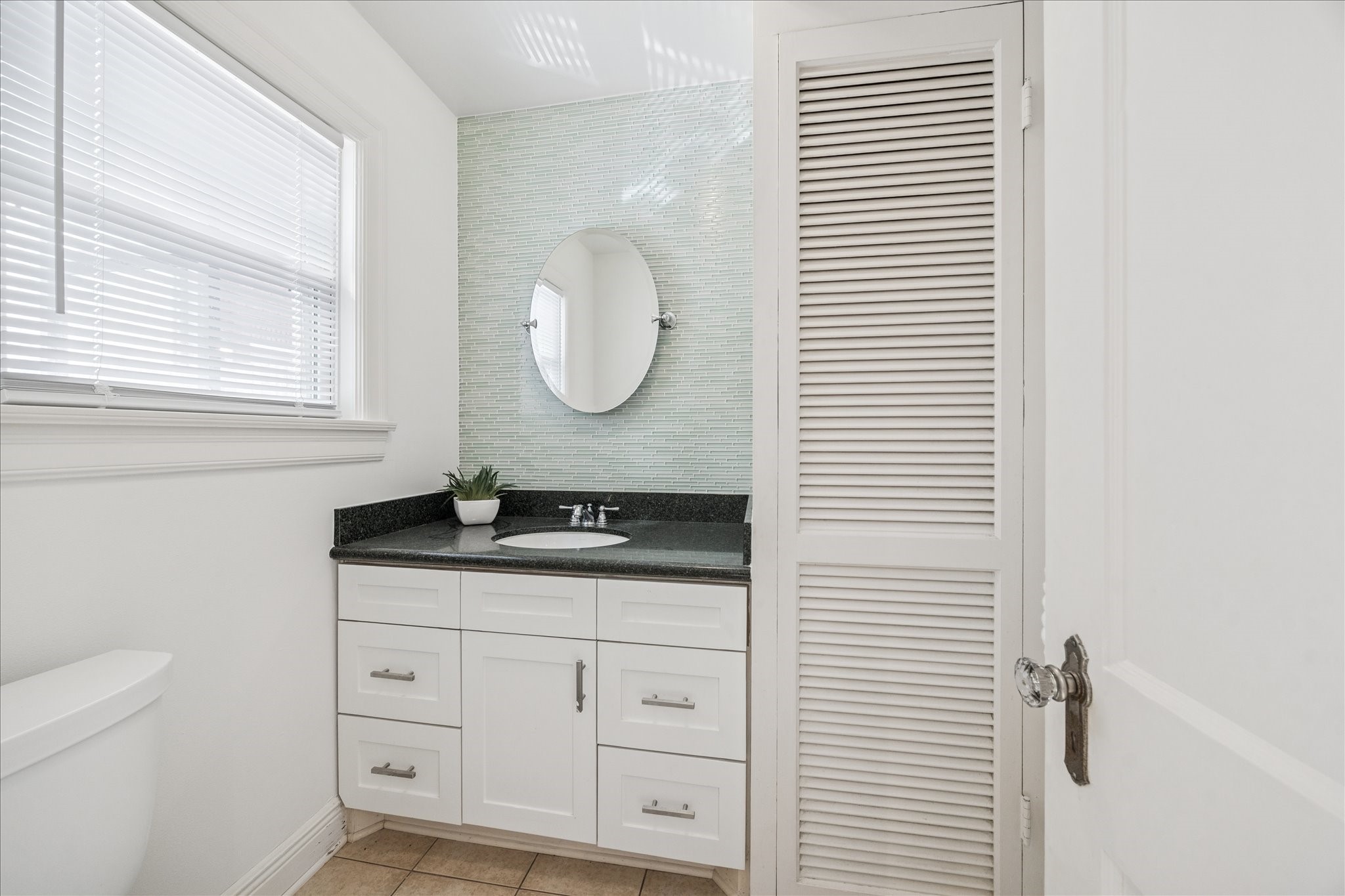 2409 Dryden Road Houston, TX 77030 - Photo 9 of 32 A conveniently located half bath just off the breakfast room offers easy access for guests or those enjoying the pool. Its placement adds everyday practicality while keeping entertaining and outdoor living effortless.