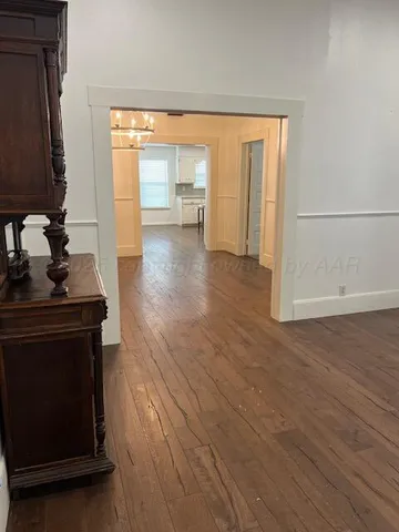 a view of a room with wooden floor and a window