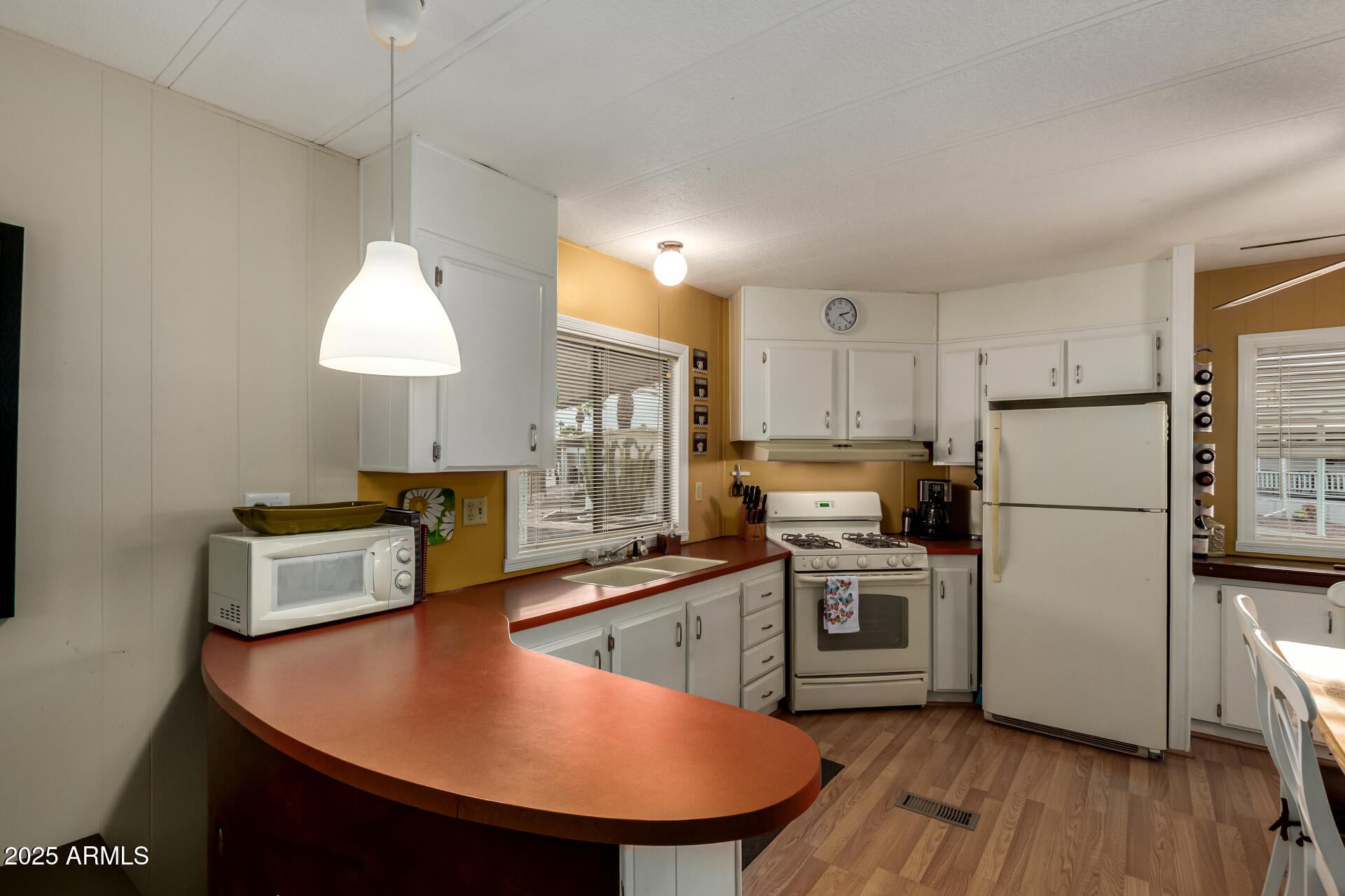 11425 East University Drive, Unit 53 Apache Junction, AZ 85120 - Photo 8 of 29 a kitchen with stainless steel appliances granite countertop a sink a stove a refrigerator a center island with wooden floor and cabinets
