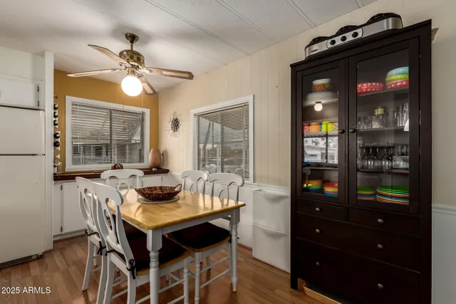 a kitchen with stainless steel appliances granite countertop a refrigerator a sink dishwasher a dining table and chairs with wooden floor