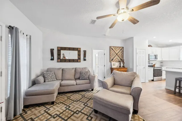a living room with furniture a ceiling fan and a rug