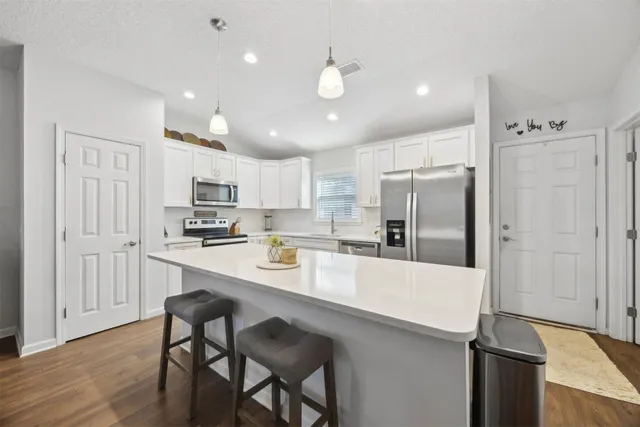 a kitchen with stainless steel appliances a refrigerator stove microwave and cabinets