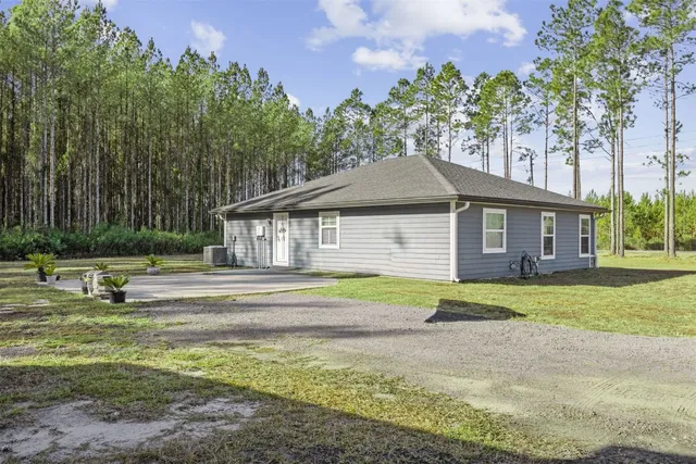 a front view of a house with a yard and trees