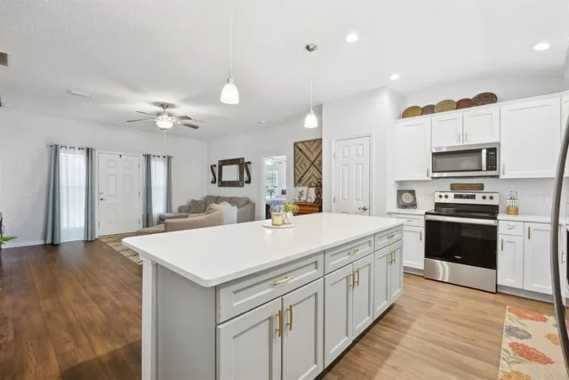 a kitchen with kitchen island a sink appliances and cabinets