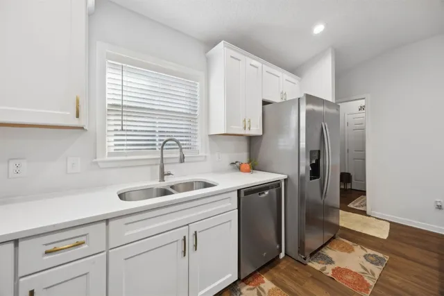 a kitchen with stainless steel appliances granite countertop a sink and a refrigerator