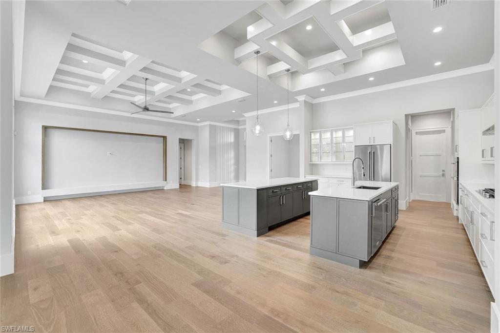 14286 Charthouse Circle Naples, FL 34114 - Photo 11 of 47 Kitchen featuring coffered ceiling, gray cabinetry, hanging light fixtures, white cabinets, and light wood-style floors