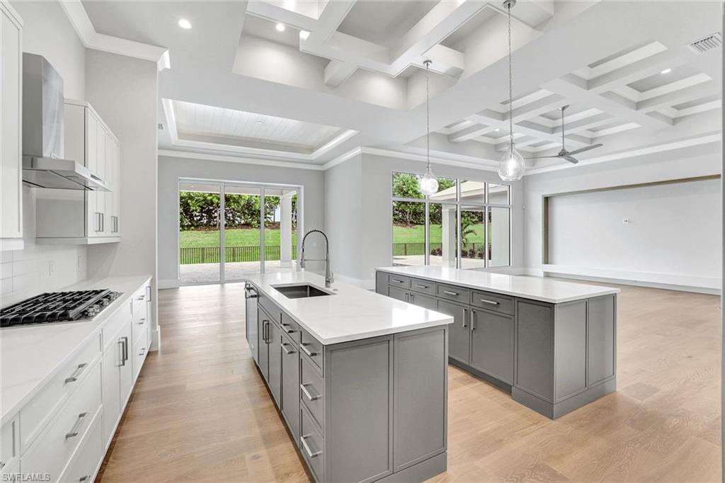 14286 Charthouse Circle Naples, FL 34114 - Photo 46 of 47 Kitchen with decorative light fixtures, gray cabinets, open floor plan, white cabinets, and coffered ceiling