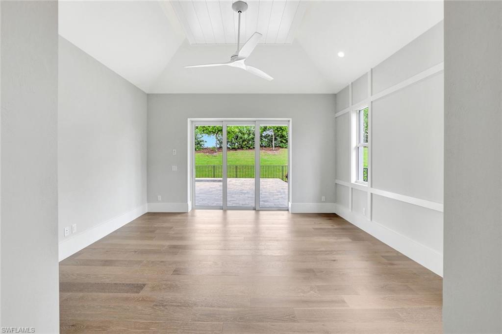 14286 Charthouse Circle Naples, FL 34114 - Photo 13 of 47 Spare room featuring wood finished floors, ceiling fan, and lofted ceiling