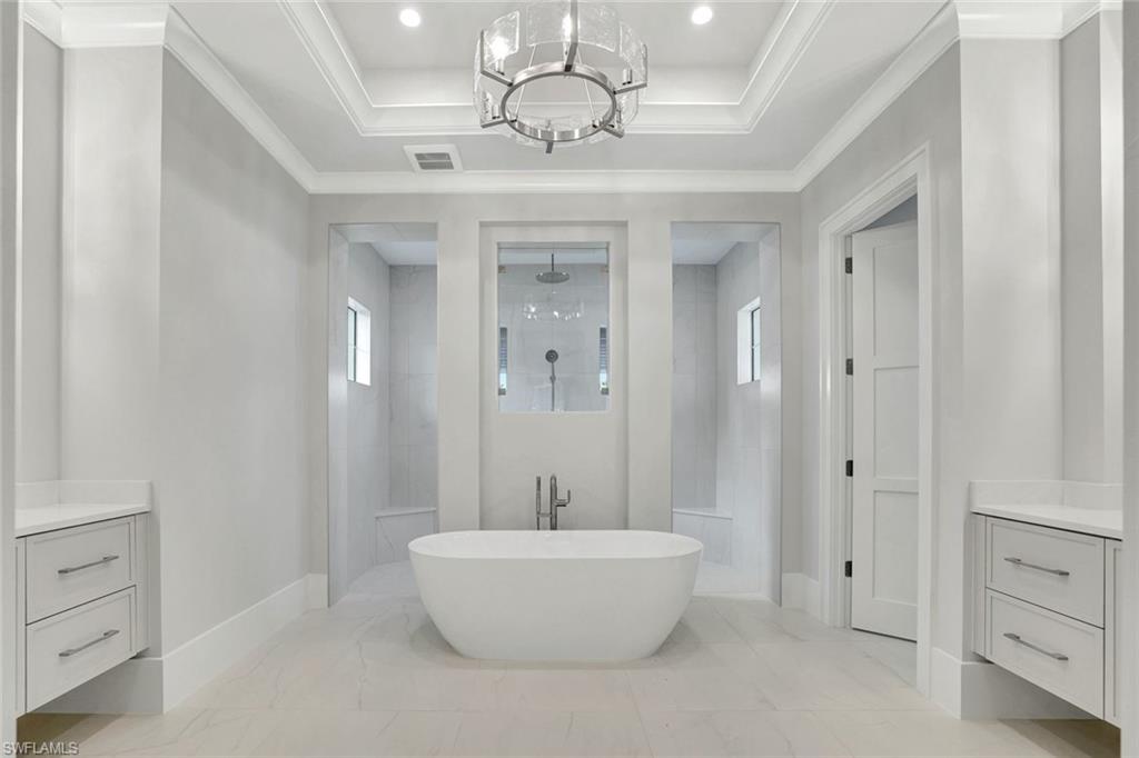 14286 Charthouse Circle Naples, FL 34114 - Photo 15 of 47 Full bathroom featuring a walk in shower, vanity, a freestanding tub, healthy amount of natural light, and ornamental molding