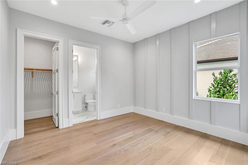 14286 Charthouse Circle Naples, FL 34114 - Photo 22 of 47 Unfurnished bedroom featuring a spacious closet, light wood-type flooring, ceiling fan, recessed lighting, and a decorative wall