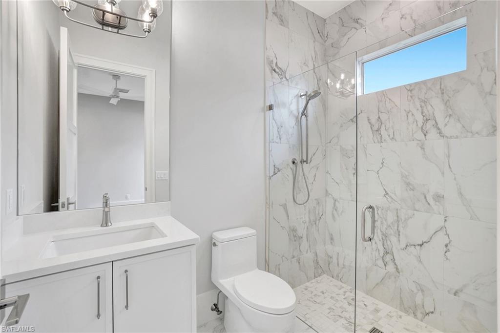 14286 Charthouse Circle Naples, FL 34114 - Photo 23 of 47 Bathroom with vanity, a marble finish shower, a chandelier, and marble finish flooring