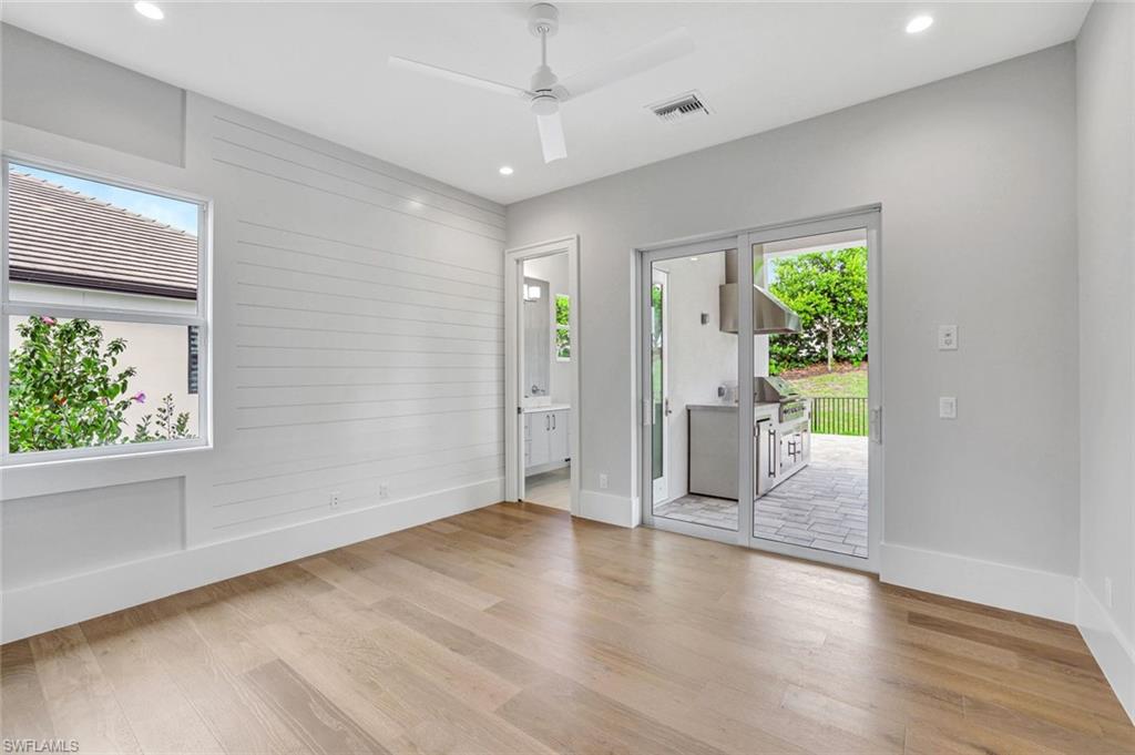 14286 Charthouse Circle Naples, FL 34114 - Photo 24 of 47 Empty room featuring light wood-type flooring, wooden walls, a ceiling fan, and recessed lighting