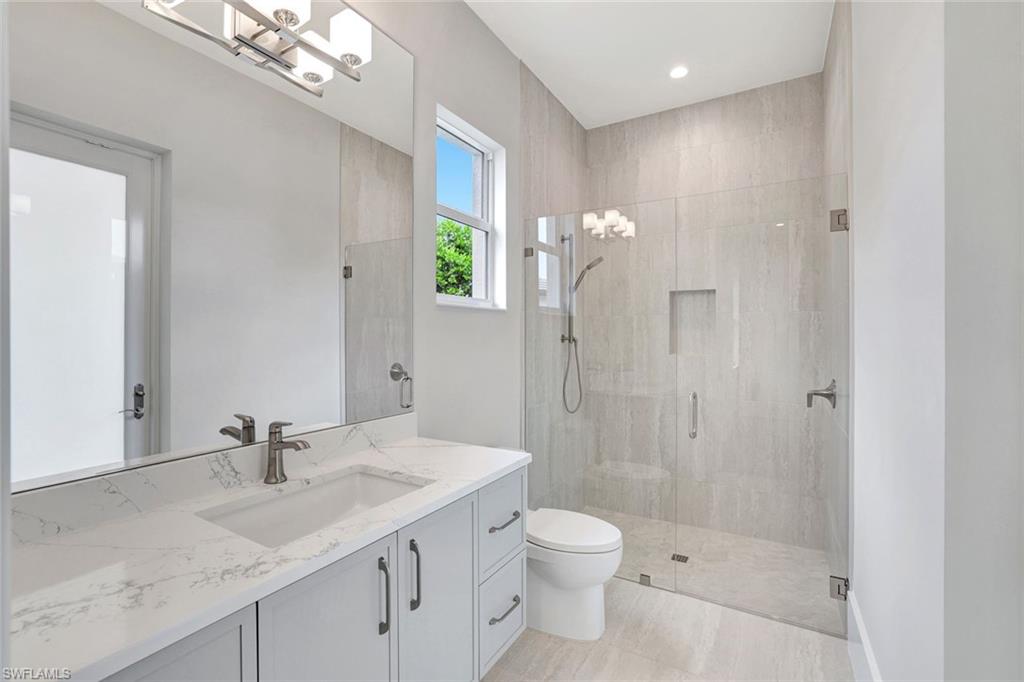 14286 Charthouse Circle Naples, FL 34114 - Photo 25 of 47 Full bathroom featuring vanity, a stall shower, and a chandelier