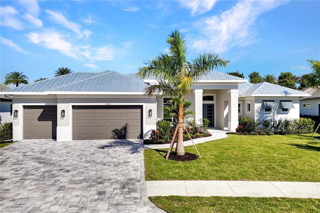 14286 Charthouse Circle Naples, FL 34114 - Photo 35 of 47 Modern home featuring a front lawn, stucco siding, and an attached garage