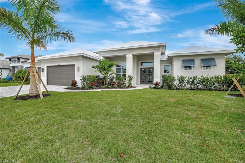 14286 Charthouse Circle Naples, FL 34114 - Photo 4 of 47 Prairie-style house with stucco siding, a front yard, a garage, driveway, and french doors