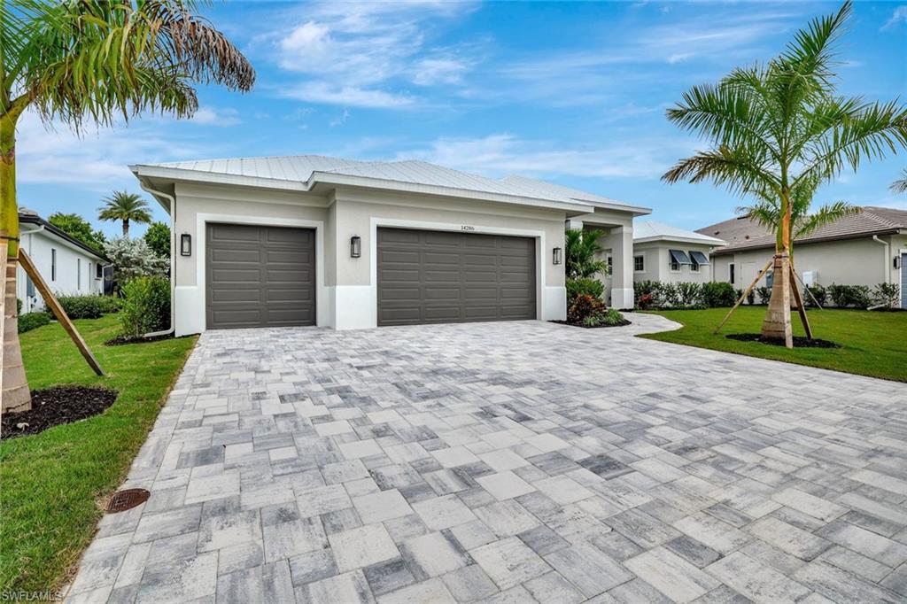 14286 Charthouse Circle Naples, FL 34114 - Photo 5 of 47 View of front of home with a front lawn, an attached garage, stucco siding, and decorative driveway