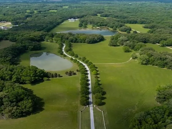 a view of a fountain in middle of the green field